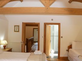 A bedroom with a bed and lamp at The Hay Barn in Halwell