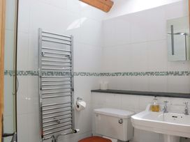 A bathroom with a towel rail, toilet, and sink at The Hay Barn in Halwell