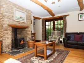 A living room with a fireplace and seating at Oak Tree in Halwell