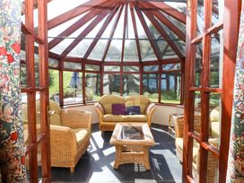 A conservatory with seating and a table at Oak Tree in Halwell