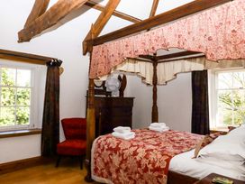 A bedroom with a four-poster bed and a dresser at Oak Tree in Halwell