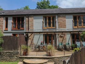 An outdoor area with a building, balcony, and patio at Fixit Cottage in Kingsbridge