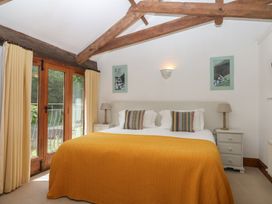 A bedroom with a bed and curtains at Fixit Cottage in Kingsbridge