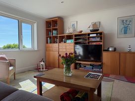 A living room with a television and bookshelf at 5 Burgh Island Causeway Bigbury-on-Sea