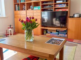 A living room with a coffee table and vase of tulips at 5 Burgh Island Causeway Bigbury-on-Sea