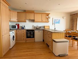 A kitchen with wooden cabinets and appliances at 5 Burgh Island Causeway in Bigbury-on-Sea