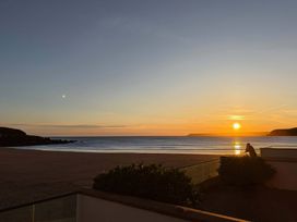 A sunset view over the ocean with a person sitting at 5 Burgh Island Causeway Bigbury-on-Sea