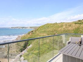 A balcony with a table and chairs overlooking the ocean at 27 Burgh Island Causeway Bigbury-on-Sea