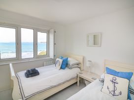 A bedroom with two beds and a view of the sea at 27 Burgh Island Causeway Bigbury-on-Sea
