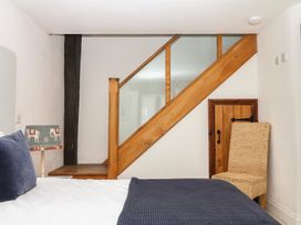 A bedroom with a staircase and a chair at Mixit Cottage in Kingsbridge