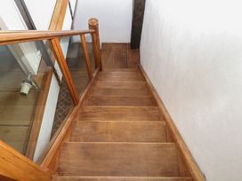 A staircase with wooden steps and glass railing at Mixit Cottage in Kingsbridge