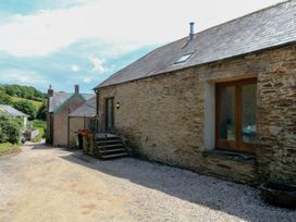 An outdoor area with a stone building and gravel path at Mixit Cottage in Kingsbridge