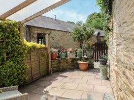 A garden with paving stones and flower pots at Mixit Cottage in Kingsbridge