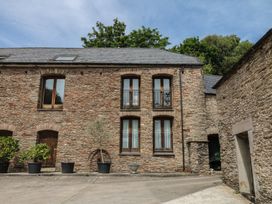 An outdoor area with stone walls and windows at Mixit Cottage in Kingsbridge