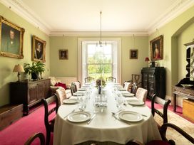 A dining room with a long table set for dinner at Parnacott in Holsworthy