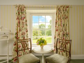 A sitting room with chairs and a table near a window at Parnacott in Holsworthy