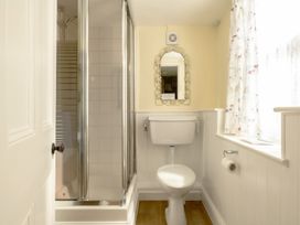 A bathroom with a shower, toilet, and mirror at Parnacott in Holsworthy