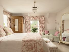 A bedroom with a bed and armchair at Parnacott in Holsworthy