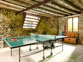 A game room with a table tennis table and stone walls at Parnacott in Holsworth