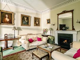 A living room with paintings and a fireplace at Parnacott in Holsworthy