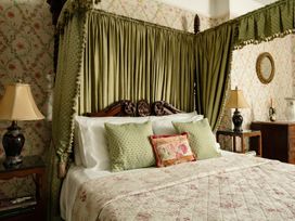 A bedroom with a four-poster bed and decorative elements at Parnacott Holsworthy