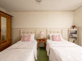 A bedroom with two beds and a wardrobe at Parnacott in Holsworthy
