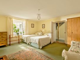 A bedroom with two beds and a wardrobe at Parnacott in Holsworthy
