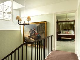 A staircase with a painting and a view of a bedroom at Parnacott in Holsworthy