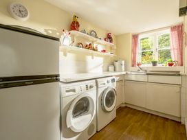 A laundry room with appliances and shelves at Parnacott in Holsworthy