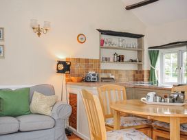 A kitchen with a dining table and sofa at Tumrose Cottage in Blisland