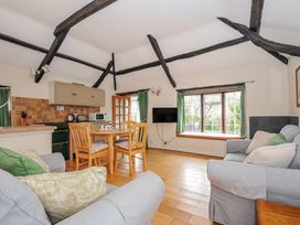 A living room with a dining table and kitchen unit at Tumrose Cottage in Blisland