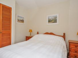 A bedroom with a bed and nightstands at Tumrose Cottage Blisland