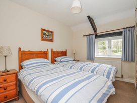 A bedroom with twin beds and a window at Tumrose Cottage in Blisland