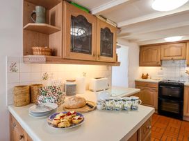 A kitchen with a countertop displaying baked goods and kitchen appliances at Agar Cottage, Trelights, near Port Isaac