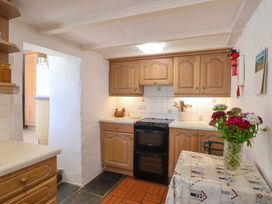 A kitchen with cabinets and a table at Agar Cottage in Trelights, near Port Isaac