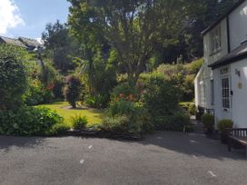 A garden with various plants and a house at Orchard Lodge in Boscastle