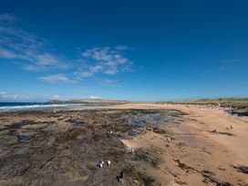 A beach with rocks and people at Grandpa Dickson's in Little Petherick