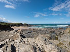 A beach with rocks and people at Grandpa Dickson's in Little Petherick