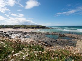 A beach scene with people swimming and enjoying the water at Grandpa Dickson's in Little Petherick