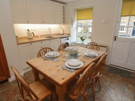 A kitchen with dining table and chairs at Primrose Cottage in Edmonton, near Wadebridge