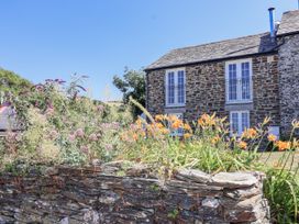 A garden with flowers and a stone wall at Atlantic View in Tintagel