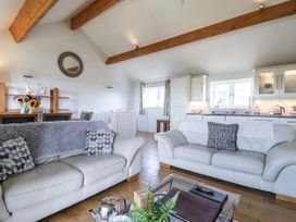 A living room with a sofa and dining table at Atlantic View in Tintagel