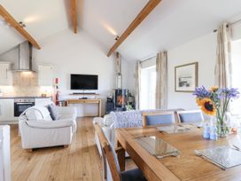 A living room with a sofa and dining table at Atlantic View in Tintagel