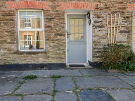 An outdoor view of a gray door and windows at Kingfisher Cottage in Edmonton, near Wadebridge