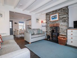 A living room with a fireplace and sofa at Kingfisher Cottage in Edmonton, near Wadebridge