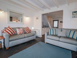 A living room with sofas and a mirror at Kingfisher Cottage in Edmonton, near Wadebridge