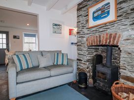 A living room with a sofa and fireplace at Kingfisher Cottage in Edmonton, near Wadebridge