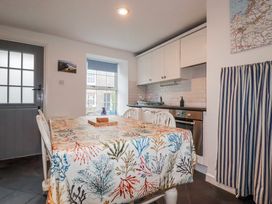 A kitchen with a table and chairs at Kingfisher Cottage, Edmonton, near Wadebridge