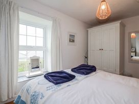 A bedroom with a bed and window at Kingfisher Cottage in Edmonton, near Wadebridge