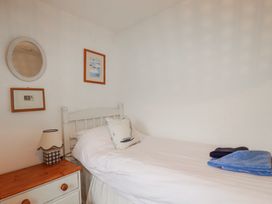 A bedroom with a bed and decorative items at Kingfisher Cottage in Edmonton, near Wadebridge